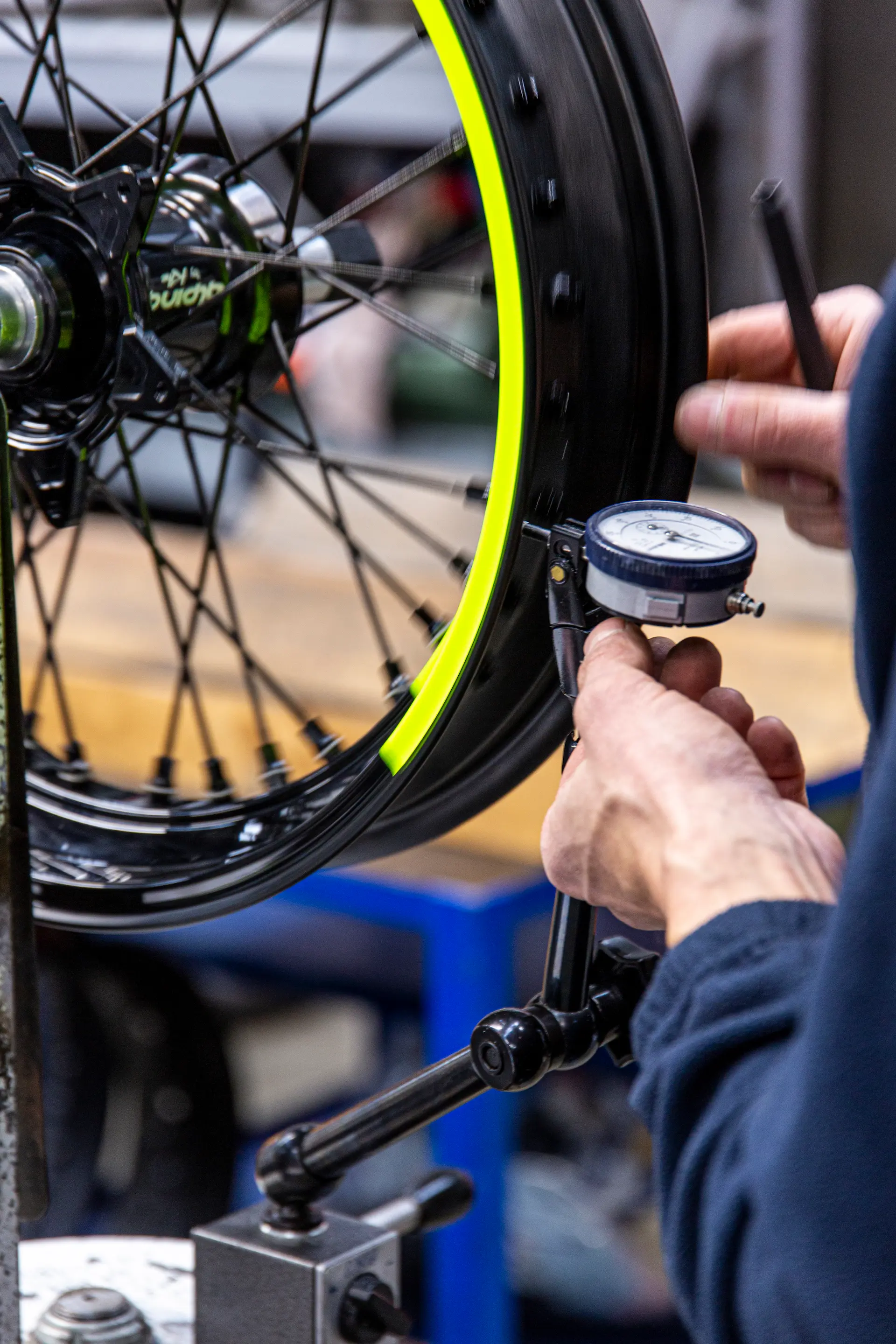 Artigiano Alpina al lavoro sulla finitura di un cerchio.